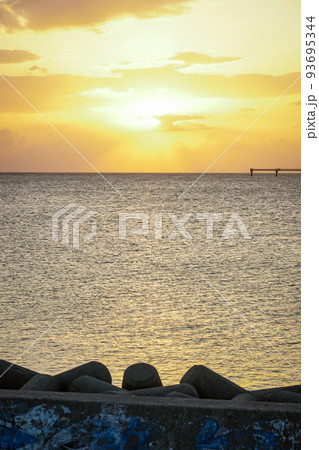 東シナ海に沈む夕陽を背景に那覇空港へと続く進入灯（沖縄県） 93695344