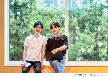 ロッジで情報収集をする若者 93698677