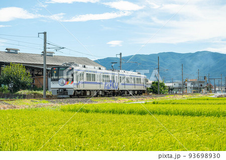 田んぼの前を走る列車　 93698930