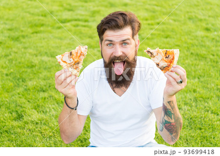 Best food ever. Man bearded hipster eating delicious pizza. Hungry greedy man hold pizza in both hands. Cheerful guy eat pizza. Summer picnic concept. Caucasian male loving Italian traditional food Best food ever. Man bearded hipster eating delicious pizza. Hungry greedy man hold pizza in both hands. Cheerful guy eat pizza. Summer picnic concept. Caucasian male loving Italian traditional food 93699418