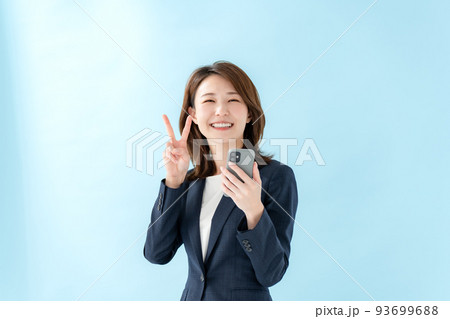 ビジネス　ピースする女性　スマートフォン 93699688
