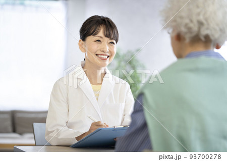 シニア女性の話を聞くミドルの女性医師 93700278