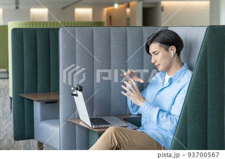 オフィスのワークブースでパソコンでweb会議をする若い男性　撮影協力「LINK FOREST]　 93700567