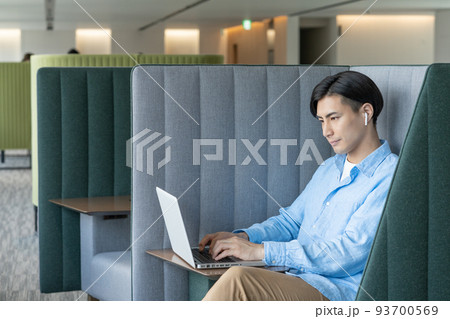 オフィスのワークブースでパソコンでweb会議をする若い男性　撮影協力「LINK FOREST]　 93700569