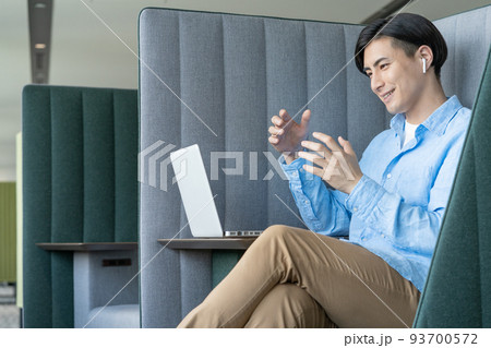 オフィスのワークブースでパソコンでweb会議をする若い男性　撮影協力「LINK FOREST]　 93700572