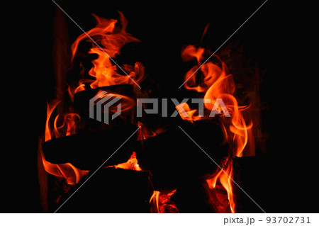 Burning firewood and coals in a stone stove. Brick oven on wood. Long tongues of flame of burning fire Burning firewood and coals in a stone stove. Brick oven on wood. Long tongues of flame of burning fire 93702731