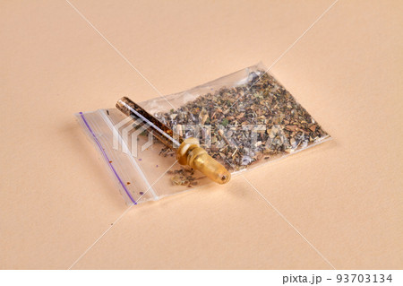 Glass pipette cigarette and pack of weed on beige background. Drug addicted smokers accesories. 93703134