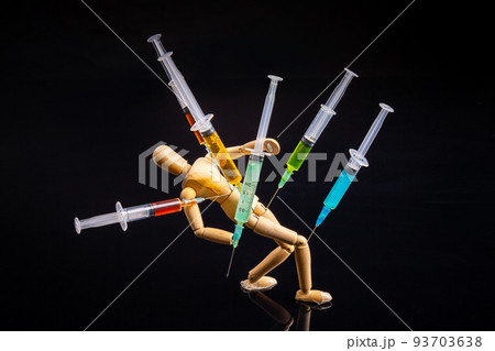 Composition of wooden mannequin with stucked syringes on black background. Drug addiction concept. 93703638