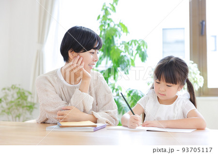 リビングで勉強をする小学生の娘と母親 リビングで勉強をする小学生の娘と母親 93705117