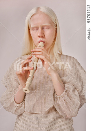 Portrait of albino girl enjoying playing on musical instrument standing on white background 93705512