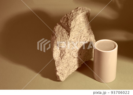 Top view of the pedestal made of porcelain for the presentation of the product on a sand background, stone and shadow from the monster. A design element with space to copy. High quality photo 93706022