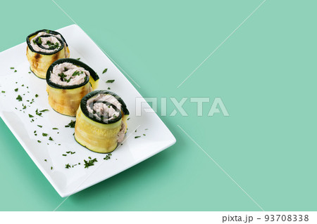 Grilled zucchini rolls with tuna and cream cheese on green background Grilled zucchini rolls with tuna and cream cheese on green background 93708338