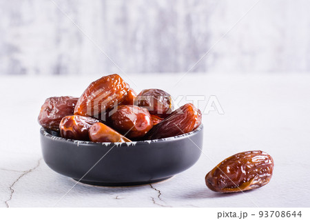 Bowl with ripe dried dates on a light background. Oriental dessert 93708644
