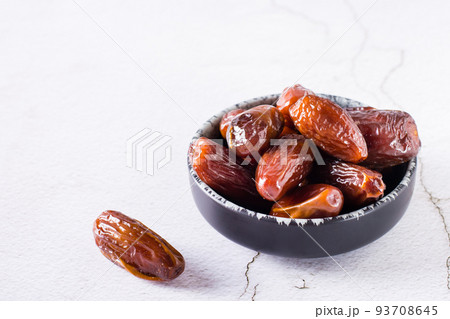 Ripe dried dates in a bowl on the table. Oriental dessert Ripe dried dates in a bowl on the table. Oriental dessert 93708645