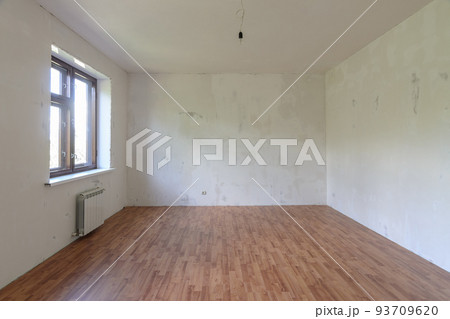 Interior of a small empty room with one window during renovation Interior of a small empty room with one window during renovation 93709620