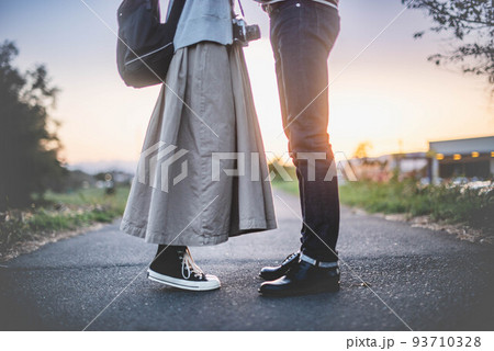 男性の目線に合わせようと女性が背伸びする夕暮れのカップル 男性の目線に合わせようと女性が背伸びする夕暮れのカップル 93710328