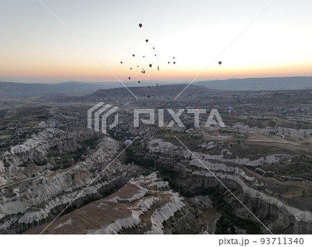Aerial cinematic drone view of colorful hot air balloon flying over Cappadocia Aerial cinematic drone view of colorful hot air balloon flying over Cappadocia 93711340