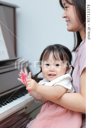 アップライトピアノを弾く1歳の女の子とママ 93713378