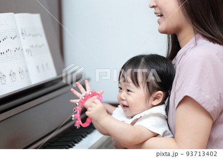 アップライトピアノを弾く1歳の女の子とママ 93713402