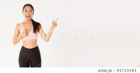 Sport, wellbeing and active lifestyle concept. Excited slim and cute asian fitness girl, female athlete pointing fingers upper right corner, showing workout equipment sale promo or gym offer Sport, wellbeing and active lifestyle concept. Excited slim and cute asian fitness girl, female athlete pointing fingers upper right corner, showing workout equipment sale promo or gym offer 93713583