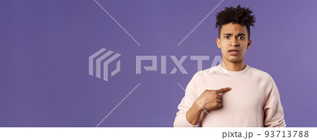 Close-up portrait of embarrassed and worried young man being named or called to principal office, pointing at himself and asking why with disbelief and anxiety, standing purple background Close-up portrait of embarrassed and worried young man being named or called to principal office, pointing at himself and asking why with disbelief and anxiety, standing purple background 93713788