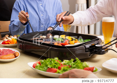 ビールを飲みながら焼肉を食べる家族 93714777