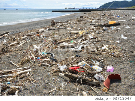 砂浜海岸の波打ち際に打ち上げられた沢山の漂流ゴミ 93715047