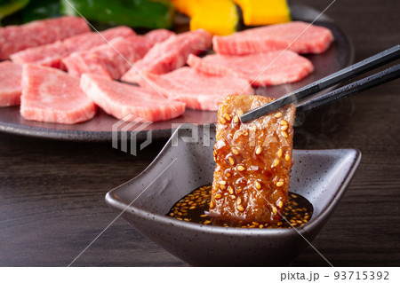 焼肉をタレをつけて食べる 焼肉をタレをつけて食べる 93715392