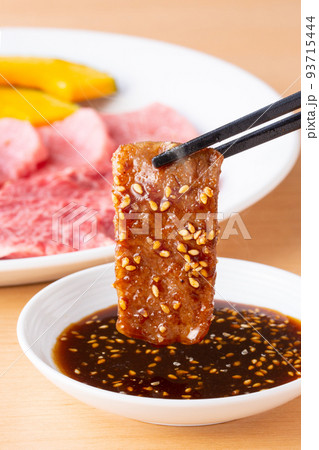 焼肉をタレをつけて食べる 焼肉をタレをつけて食べる 93715444