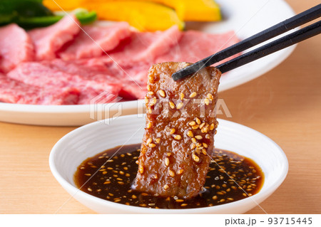焼肉をタレをつけて食べる 93715445