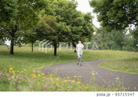 公園でジョギングをする女性の様子 93715547