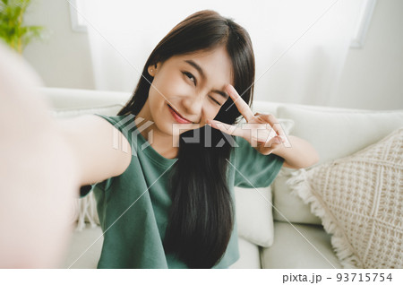 Pretty young asian female with big smile sitting at living room 93715754