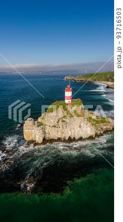 Basargin Lighthouse on a rocky island with a suspension bridge to it. Drone view Basargin Lighthouse on a rocky island with a suspension bridge to it. Drone view 93716503