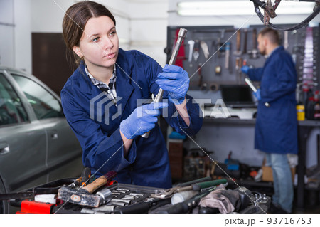 Female master is choosing instruments in workshop Female master is choosing instruments in workshop 93716753