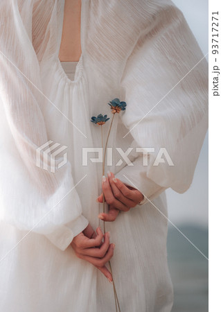 花を持つ女性の後ろ姿 93717271