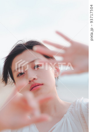 海辺の顔を隠す女性 93717504