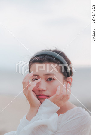 海辺の顔を隠す女性 海辺の顔を隠す女性 93717518