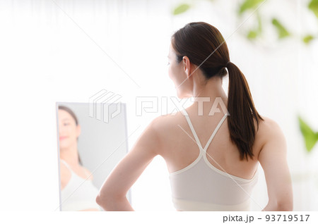 鏡をみて気にする女性 93719517