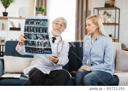 Senior male doctor explaining results of x-ray MRI image to his middle aged female patient Senior male doctor explaining results of x-ray MRI image to his middle aged female patient 93721193