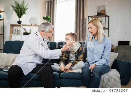 Mature doctor groping checking pain and swelling in the neck sore throatof sick male patient boy Mature doctor groping checking pain and swelling in the neck sore throatof sick male patient boy 93721247