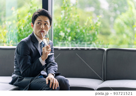 浮かない表情でシャンパンを飲むスーツを着た男性 浮かない表情でシャンパンを飲むスーツを着た男性 93721521