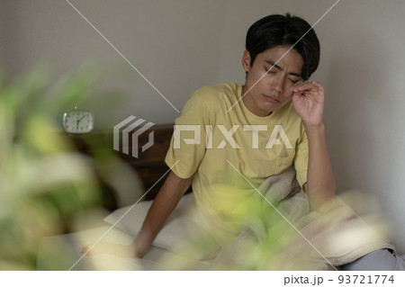 睡眠・寝不足・頭痛でベッドから出れない男性イメージ 93721774
