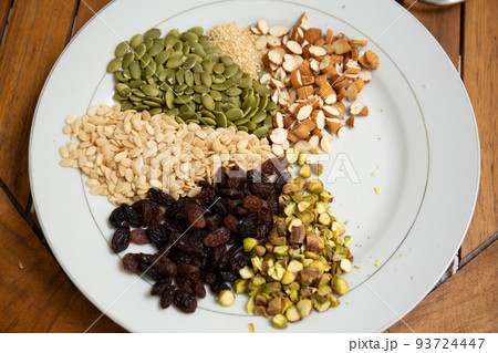 Close up shot a dish full of different seeds and nuts, chestnut,almond, raisin, pumpkins, seasame. Healthy eating concept Close up shot a dish full of different seeds and nuts, chestnut,almond, raisin, pumpkins, seasame. Healthy eating concept 93724447