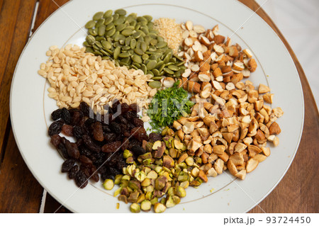 Close up shot a dish full of different seeds and nuts, chestnut,almond, raisin, pumpkins, seasame. Healthy eating concept Close up shot a dish full of different seeds and nuts, chestnut,almond, raisin, pumpkins, seasame. Healthy eating concept 93724450