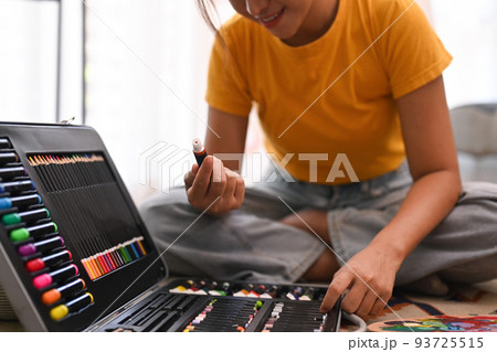 Young beautiful woman artist painting on canvas with oil colors in bright living room. Hobby, art and people concept 93725515