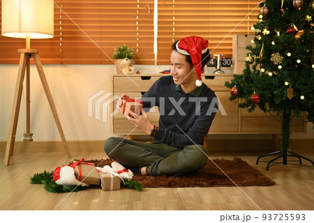 Happy man preparing for Christmas and New Year holidays season at home. Holidays preparation and creativity concept Happy man preparing for Christmas and New Year holidays season at home. Holidays preparation and creativity concept 93725593