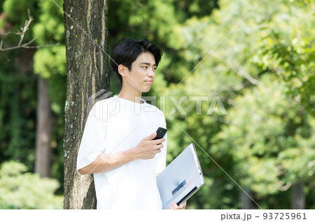 屋外で片手にスマホを持つ男性 屋外で片手にスマホを持つ男性 93725961