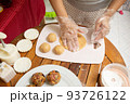 Female hands making dough for mooncake, homemade cantonese moon cake pastry on baking tray before baking for traditional festival. Travel, holiday, food concept 93726122
