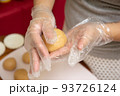 Female hands making dough for mooncake, homemade cantonese moon cake pastry on baking tray before baking for traditional festival. Travel, holiday, food concept 93726124