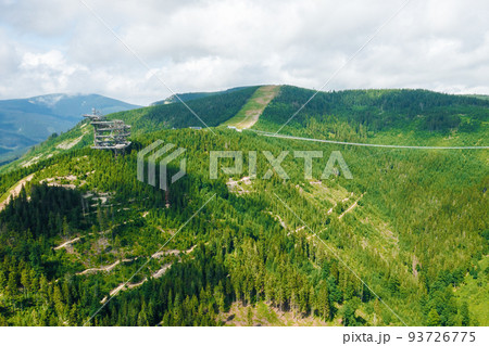 Aerial view of the worlds longest 721 meter suspension footbridge Sky bridge and observation tower the Sky walk in the forest, between mountains, Dolni Morava Ski Resort, Czech Republic. Aerial view of the worlds longest 721 meter suspension footbridge Sky bridge and observation tower the Sky walk in the forest, between mountains, Dolni Morava Ski Resort, Czech Republic. 93726775